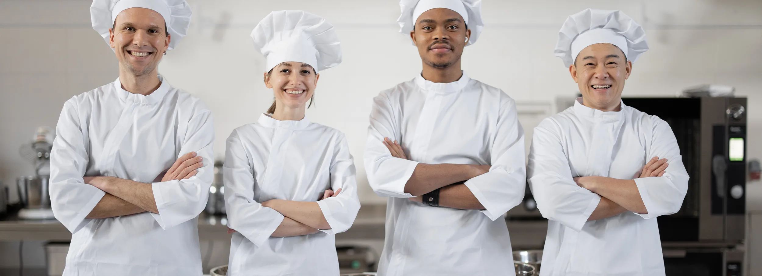 Smiling chefs in crisp white uniforms