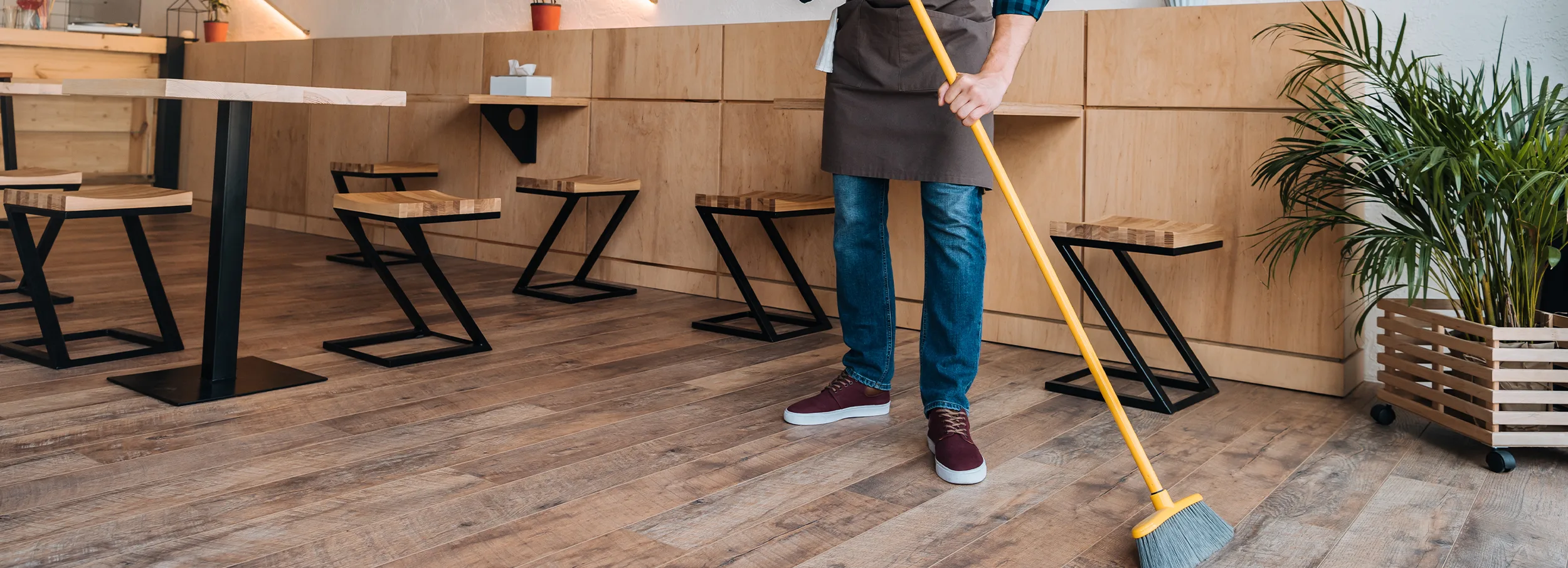 Employee sweeping restaurant floor